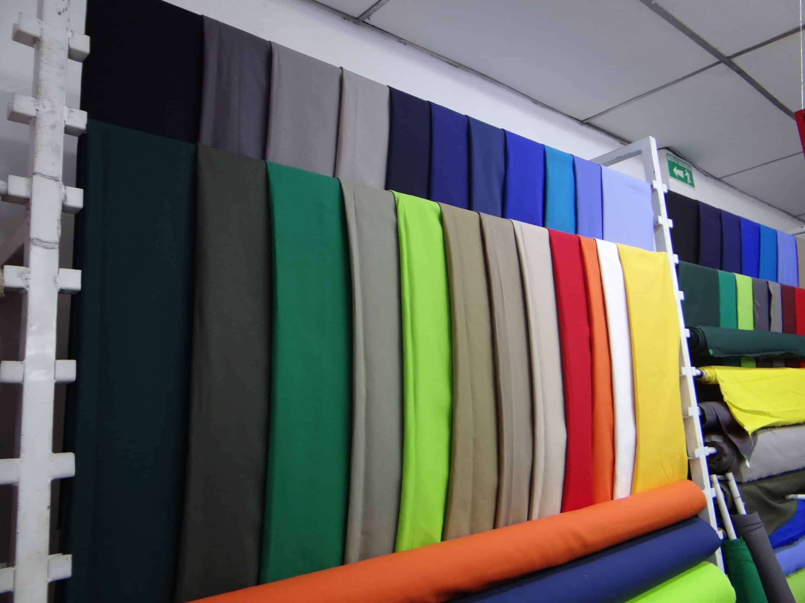 Cueros y tejidos en una variedad de colores en display en la tienda Pumotex, ideales para tapicería, moda y proyectos personalizados. Materiales de alta calidad disponibles para distintas aplicaciones.