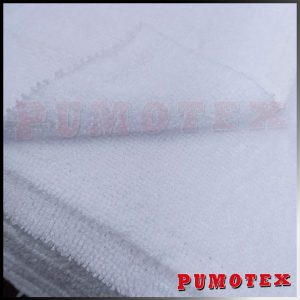 Sabanas de tela blanca con logo Pumotex bordado en el centro, textiles para limpieza y uso industrial en empresa Pumotex.