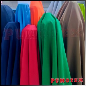 Alt text: Múltiples telas en diferentes colores, dobladas y colgadas, utilizadas en tapicería, decoración y protección de superficies.